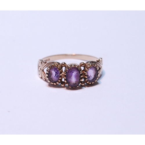 145 - 9ct gold amethyst three-stone ring set with three graduated amethysts, stamped '375', size P, 2g gro... 