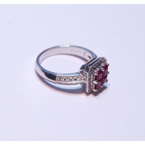 148 - 18ct white gold ruby and diamond ring set with four rubies, measuring in total .90ct, flanked by sma... 