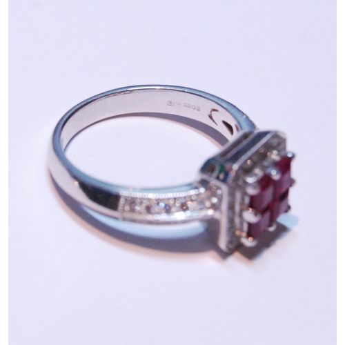 148 - 18ct white gold ruby and diamond ring set with four rubies, measuring in total .90ct, flanked by sma... 