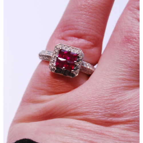 148 - 18ct white gold ruby and diamond ring set with four rubies, measuring in total .90ct, flanked by sma... 