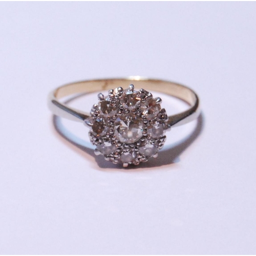 149 - Diamond cluster ring set with a brilliant-cut stone measuring just under .5ct, surrounded by smaller... 