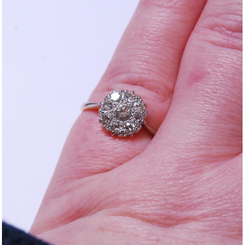 149 - Diamond cluster ring set with a brilliant-cut stone measuring just under .5ct, surrounded by smaller... 