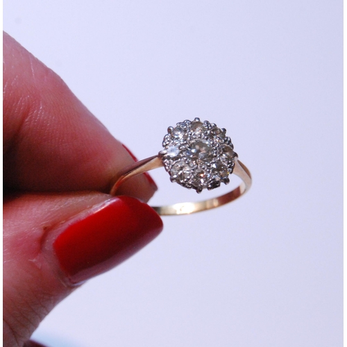 149 - Diamond cluster ring set with a brilliant-cut stone measuring just under .5ct, surrounded by smaller... 