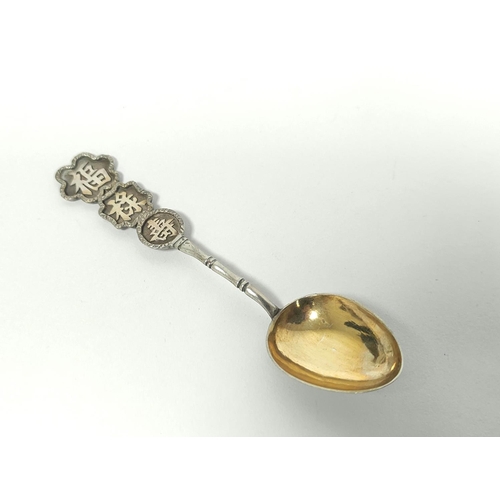 13 - Japanese silver spoon modelled as a Geisha and a Chinese spoon. (2).