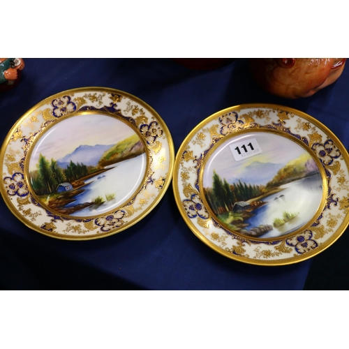 111 - Pair of Noritake cabinet plates with hand-painted landscape scenes and cobalt and gilt borders.