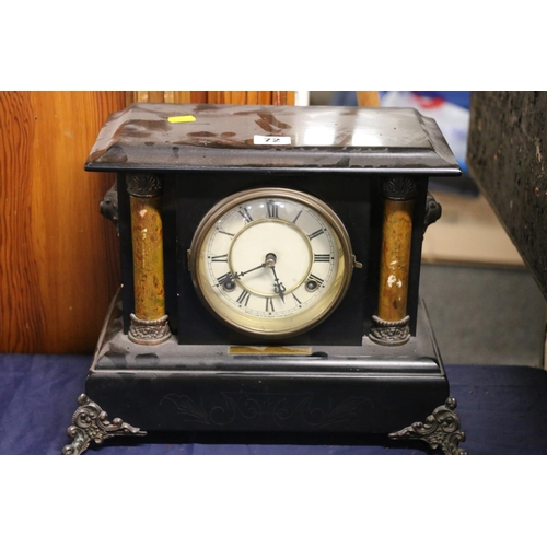 72 - Mantel clock decorated with two columns flanking the clock face, 28cm high.