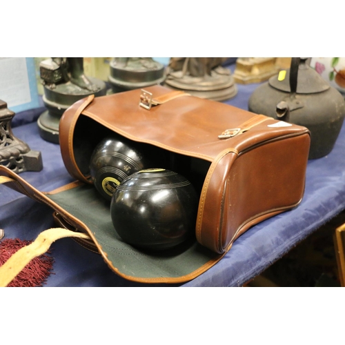 96 - Set of lawn bowls in brown leather bag and two other lawn bowls.