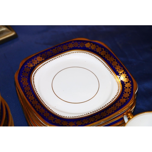 124 - Roslyn China teaset decorated with blue and gilt rim.