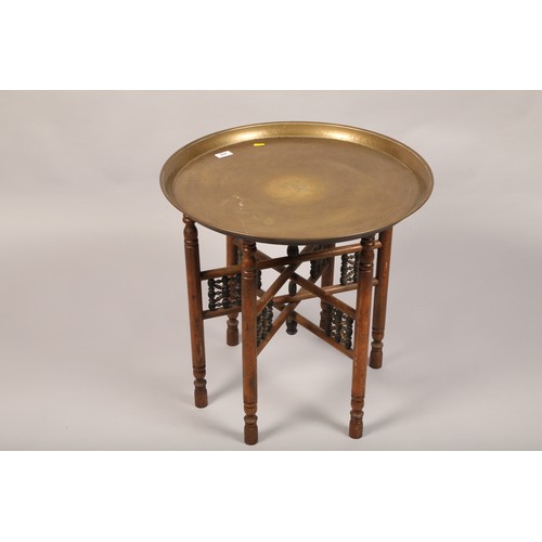 518 - 20th century Indian brass topped folding table; 57cm diameter