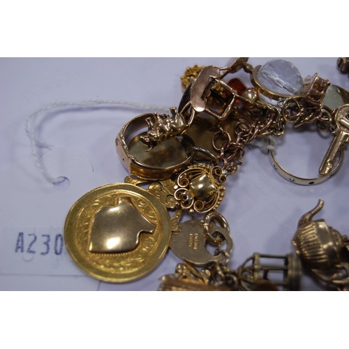 133 - 9ct gold charm bracelet with multiple charms and gems dependant to include a medal, ring, fob, penda... 