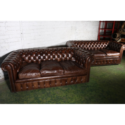 588 - Pair of brown leather button-back three-seater Chesterfield sofas, 196cm long.