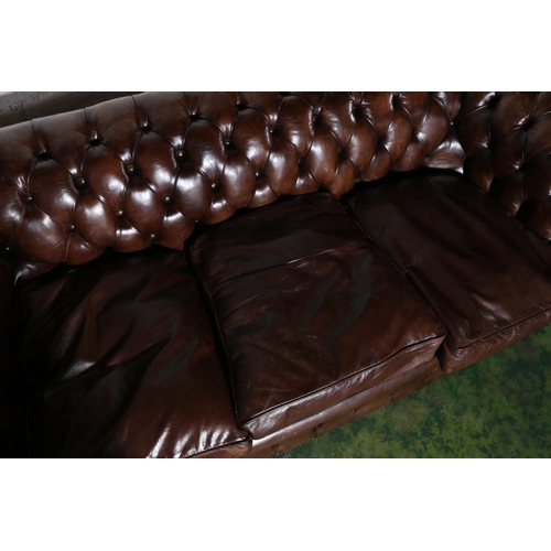 588 - Pair of brown leather button-back three-seater Chesterfield sofas, 196cm long.