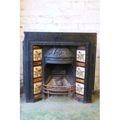 592 - A Victorian cast iron fire surround, with foliate decorated dome hood over fire basket flanked by li... 