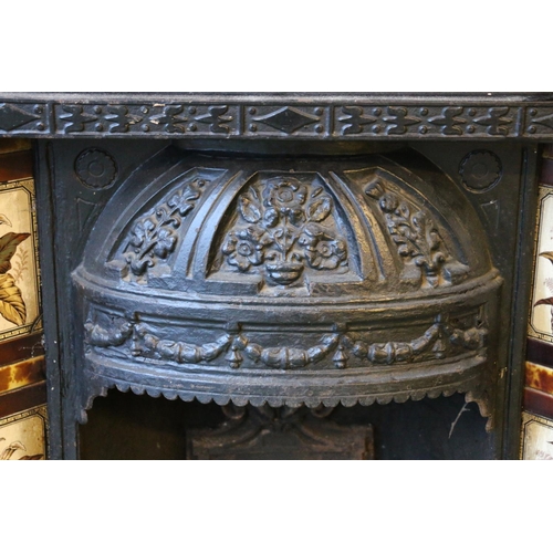 592 - A Victorian cast iron fire surround, with foliate decorated dome hood over fire basket flanked by li... 