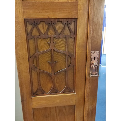 582 - Arts and Crafts wardrobe, probably ash, the mirror door flanked by two fret panels of stylised flowe... 