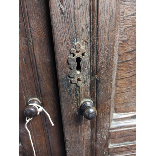 611 - Antique oak cupboard, moulded pediment above pair of triple panel doors on panelled box base and sti... 