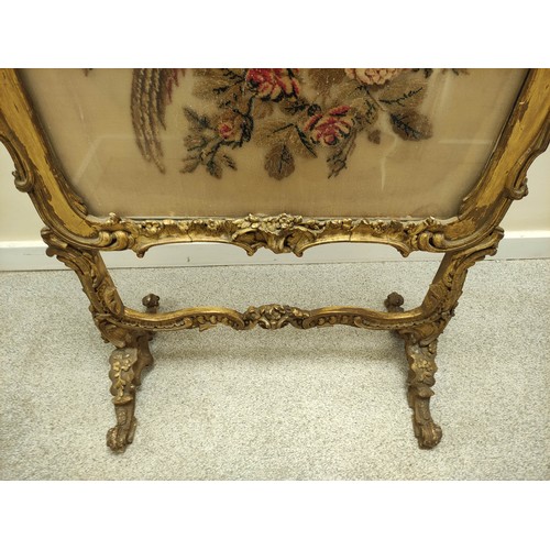 621 - Ornate 19th century firescreen, the foliate scroll gilt frame enclosing a cushioned tapestry depicti... 