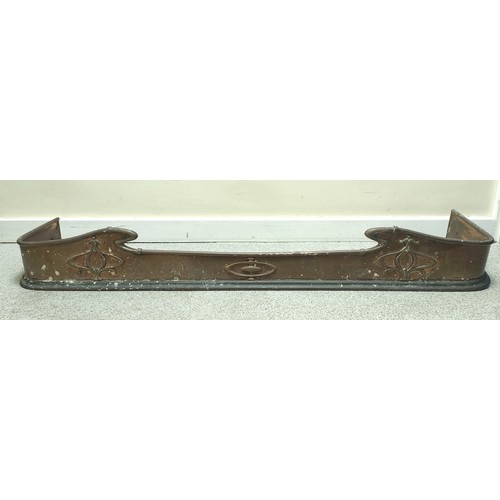 622 - Copper fire fender, c.1900, with scroll edge and motifs in relief, 140cm wide.