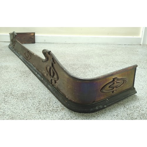 622 - Copper fire fender, c.1900, with scroll edge and motifs in relief, 140cm wide.