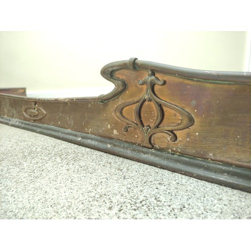 622 - Copper fire fender, c.1900, with scroll edge and motifs in relief, 140cm wide.