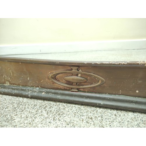 622 - Copper fire fender, c.1900, with scroll edge and motifs in relief, 140cm wide.