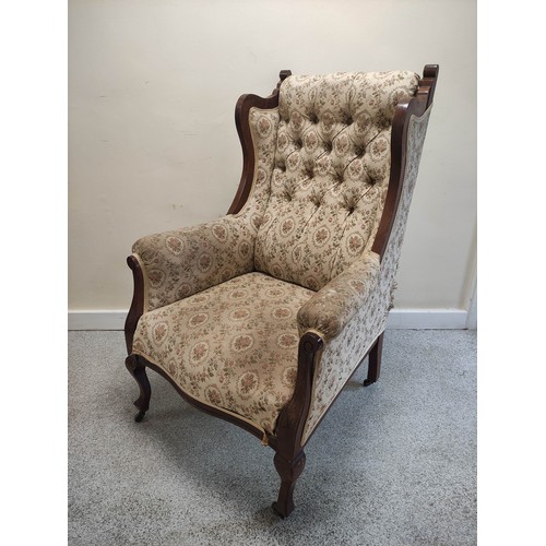 636 - Edwardian walnut framed wing armchair with button back and show-wood side rails and arm terminals on... 