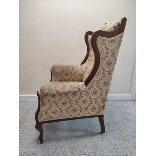 636 - Edwardian walnut framed wing armchair with button back and show-wood side rails and arm terminals on... 