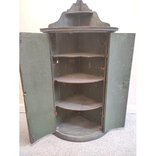 637 - Georgian painted pine corner cupboard, the two doors enclosing shaped shelves and each painted overa... 