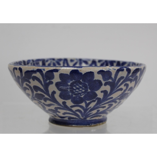 259 - Middle Eastern small earthenware blue and white circular bowl decorated with stylised flowers and fo... 