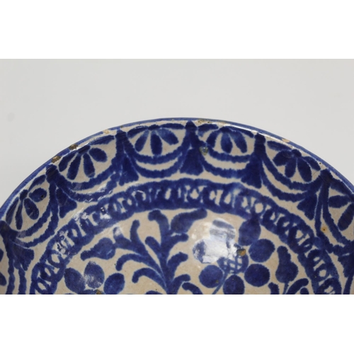 259 - Middle Eastern small earthenware blue and white circular bowl decorated with stylised flowers and fo... 