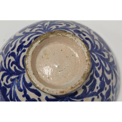 259 - Middle Eastern small earthenware blue and white circular bowl decorated with stylised flowers and fo... 