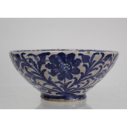 259 - Middle Eastern small earthenware blue and white circular bowl decorated with stylised flowers and fo... 