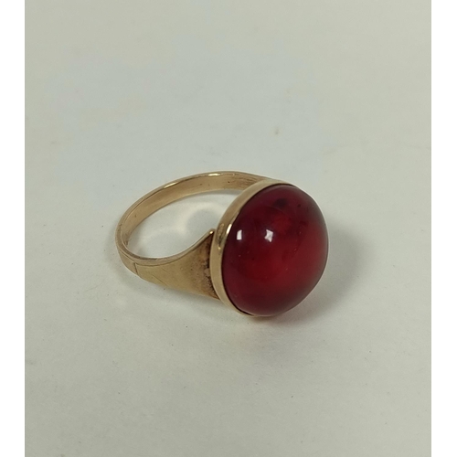 110 - Red amber cabochon ring and a pair of similar cuff links, in gold, 9.7g.