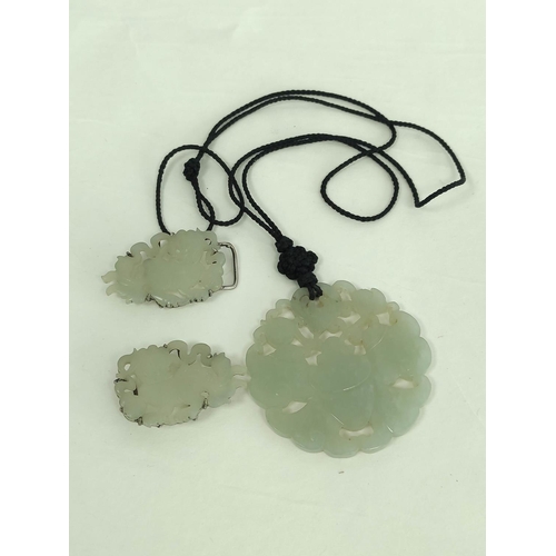 106 - Chinese celadon jade circular pendant and a similar buckle in two parts. (3).