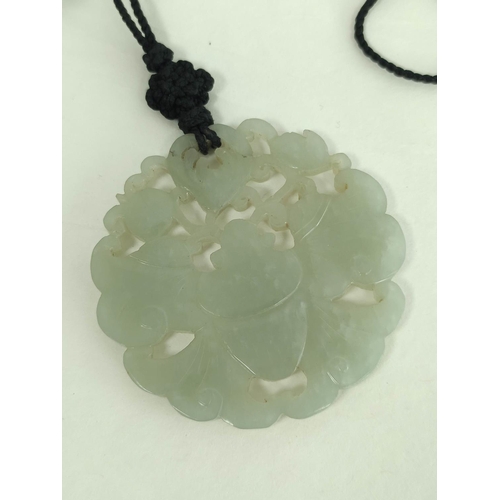 106 - Chinese celadon jade circular pendant and a similar buckle in two parts. (3).