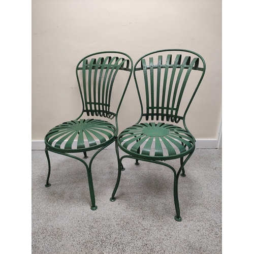 658 - Attributed to Francois Carre, a pair of green painted wrought iron cafe chairs with sunburst decorat... 