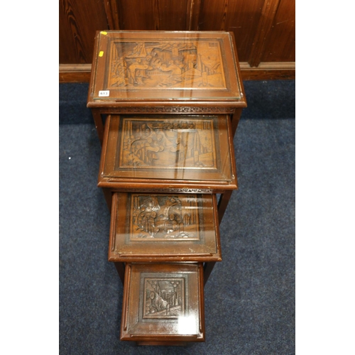 613 - Quatro of Chinese nesting tables, each with a carved top and glass plates, smallest with drawer, lar... 