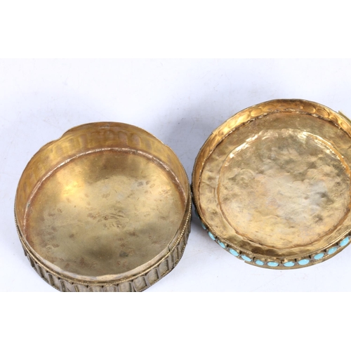 12 - Tibetan metal work box, set with coral and blue stones, decorated with a Buddha, 8cm diameter.