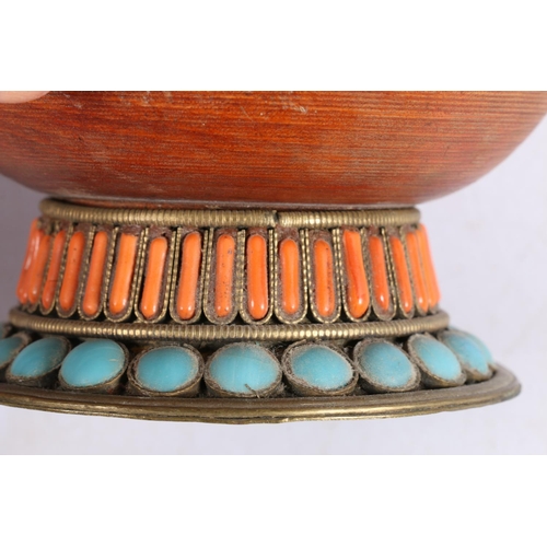 13 - Tibetan treen pencil jar and cover, decorated with metal work banding and set with coral and blue st... 