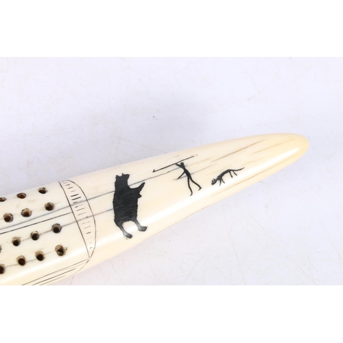 142 - Scrimshaw cribbage board of Inuit design, 33cm long.