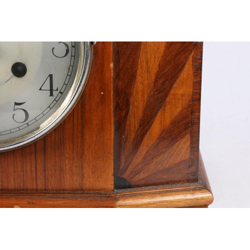 27 - Mahogany and inlaid mantel clock, having shaped sides, raised on shaped supports, 33cm wide.