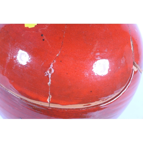 58 - Red glazed abstract Studio Pottery jar and cover, 32cm.  (a/f)