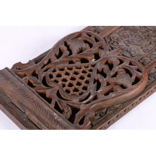 6 - Indian heavily carved book slide, decorated with foliage and flowerheads, 68cm wide fully extended.