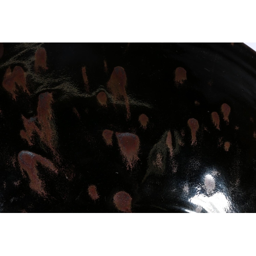 74 - Studio Pottery shallow bowl, decorated in black over brown glaze, 39cm diameter.