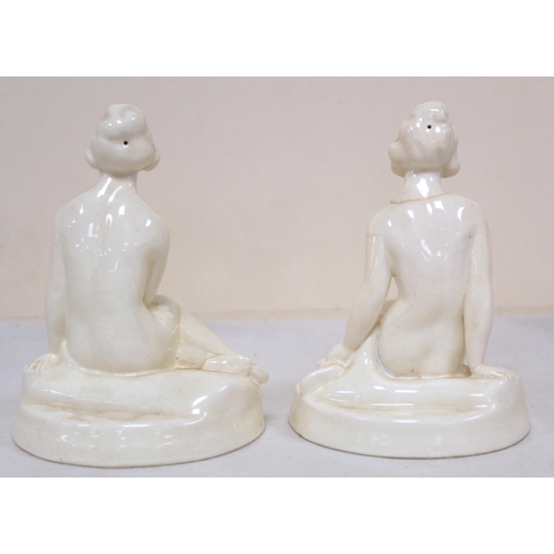 480 - A pair of Royal Worcester white porcelain Art Deco style figures of two seated female nudes on natur... 