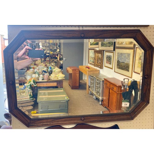 378 - 1930s oak framed octagonal bevel edged wall mirror; 48cm x 76cm