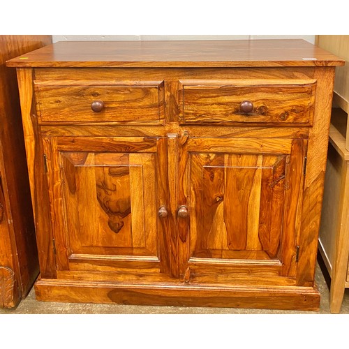 524 - Eastern hardwood two door and two drawer cabinet; raised on plinth base