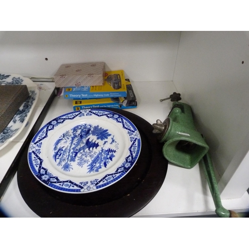 166 - Victorian ashet, tiled tray, brass grilles, large stapler, kitchen mincer, books etc (one shelf).