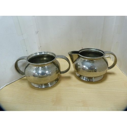 246 - Liberty & Co., three-piece hammered pewter tea set, no. 01075.