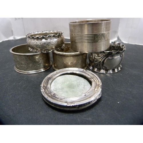 311 - Five assorted silver napkin rings, 103g gross, and a small silver-mounted photograph frame.  (6... 